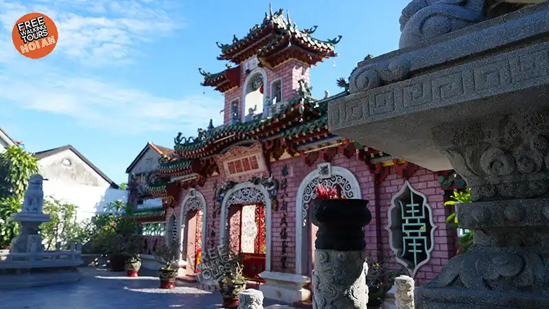 Ornate red and gold entrance of the Fujian Assembly Hall in Hoi An Ancient Town, showing dragon reliefs and carved wooden doors.